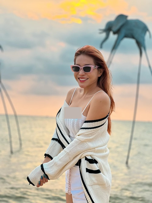 Nữ diễn viên hài gợi cảm trong set trang phục gồm áo hai dây, quần short cùng áo cardigan tông trắng.