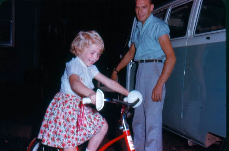 Bé gái vui thích khi tập xe đạp dưới sự giám sát của người cha. Ảnh VT