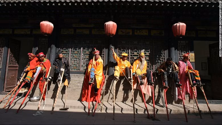Một buổi biểu diễn cà kheo trên đường phố Pingyao thu hút sự quan tâm của nhiều người.
