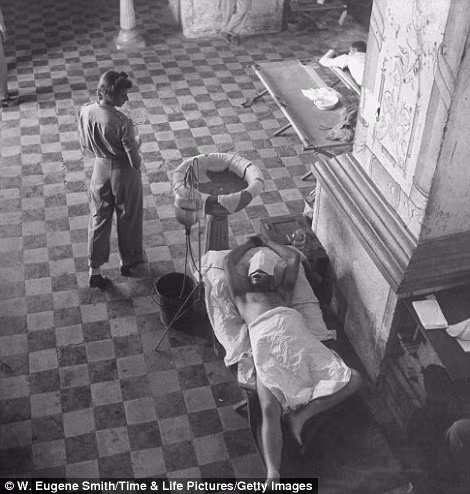 Một binh sĩ Mỹ nằm trên giường bệnh chờ phẫu thuật vết thương do súng bắn phải khi làm nhiệm vụ tại mặt trận Thái Bình Dương. Ảnh chụp tại một nhà thờ ở Leyte, Philippines trong Chiến tranh thế giới 2.