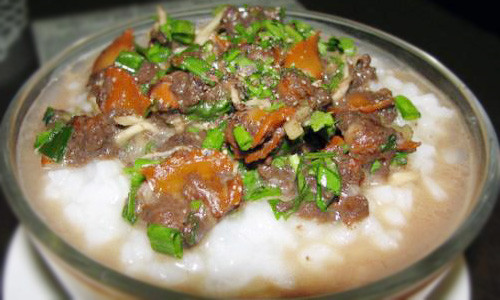 Cháo sò huyết không chỉ có giá trị dinh dưỡng cao mà còn là một trong những bài thuốc chữa bệnh. Phi thơm tỏi với dầu ăn và cho gạo vào xào cho săn lại, sau đó thêm một tô nước vào nấu cho đến khi gạo nở bung. Sò huyết tách vỏ lấy thịt và xào thịt sò huyết với tỏi cho vừa chín tới. Ảnh: thanhphohomnay