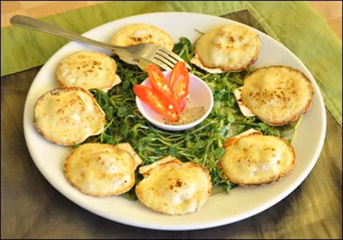 Sò nướng phô mai. Vị ngọt của sò kết hợp với vị béo thơm của phô mai giúp món ăn trở nên vô cùng hấp dẫn. Sò sơ chế sạch đặt lên vỉ, phô mai phủ kín lên trên từng con sò và nướng trên bếp than. Khi thấy sò thơm là có thể thưởng thức. Ảnh: amthuc360