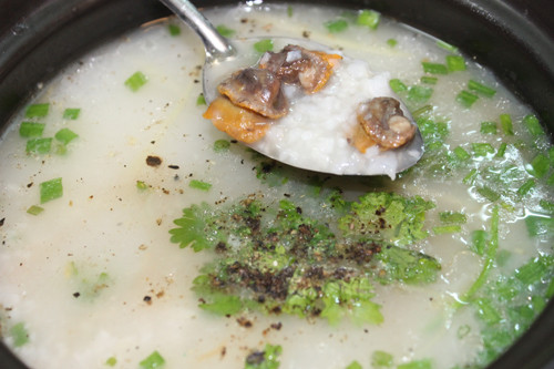 Cháo chín, múc vào tô, rắc hành ngò, hành phi và tiêu cho thơm. Cháo ăn kèm với rau cải xanh cắt nhỏ, giá đỗ, ít nước mắm ngon, ít ớt cay và lát chanh chua. Ảnh: tuvangiamcan