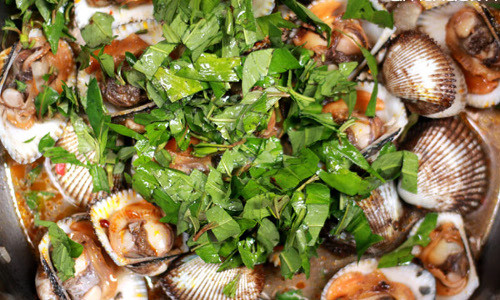 Phi thơm tỏi rồi cho sò vào xào chín, thêm ớt sa tế, xào nhanh tay lửa lớn để sò không bị dai. Nêm mắm, muối, hạt nêm vừa ăn rồi cho rau răm vào. Món ăn đậm đà, hấp dẫn với vị thơm của rau răm, vị cay của sa tế. Ảnh: saigonamthuc