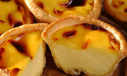 Bánh trứng nướng (Egg Tart). Chiếc bánh trứng kiểu Tây nhỏ xinh này được giới trẻ Hà thành biết đến nhiều bởi nó là món tráng miệng quen thuộc của một hãng gà rán nổi tiếng. Bánh gồm phần trứng ngọt ngậy đựng trong lớp Tart làm từ bột nướng giòn tan. Bánh mềm, tan trong miệng như kem, béo mà không ngấy. Ảnh: webtretho