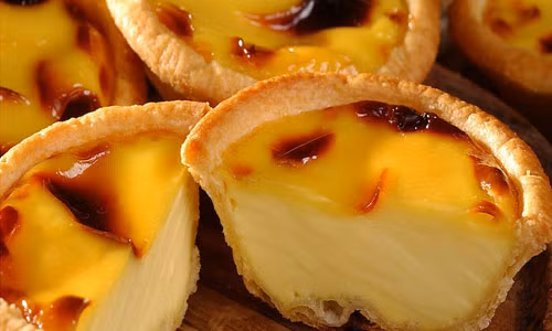 Bánh trứng nướng (Egg Tart). Chiếc bánh trứng kiểu Tây nhỏ xinh này được giới trẻ Hà thành biết đến nhiều bởi nó là món tráng miệng quen thuộc của một hãng gà rán nổi tiếng. Bánh gồm phần trứng ngọt ngậy đựng trong lớp Tart làm từ bột nướng giòn tan. Bánh mềm, tan trong miệng như kem, béo mà không ngấy. Ảnh: webtretho