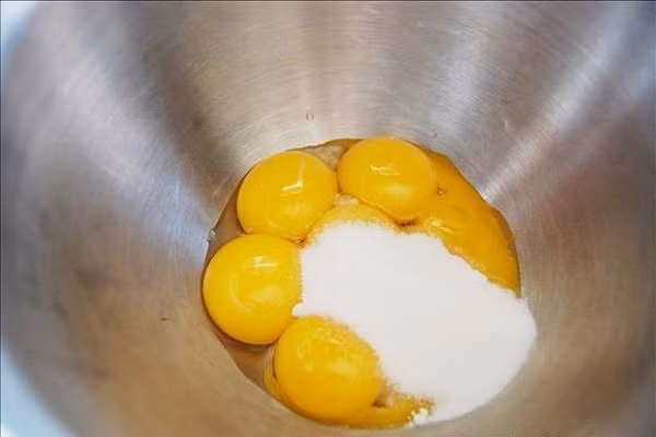 Đầu tiên, bạn trộn bột trà xanh với bột mỳ rây mịn với nhau. Tách riêng lòng trắng và lòng đỏ. Dùng hỗn hợp lòng đỏ cho sữa tươi, đường, dầu ăn vào đánh tan đều. (Ảnh: banh.com.vn)