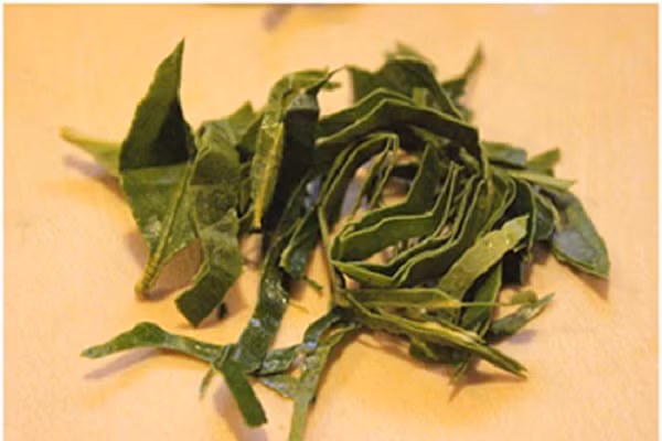 Lá chanh rửa sạch thái sợi nhỏ để xào. (Ảnh: toinayangi.com)