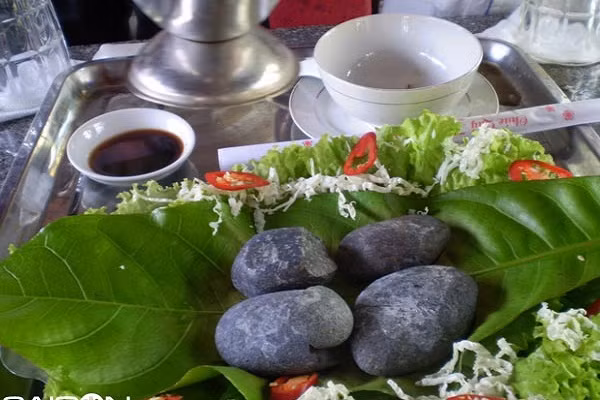 Sỏi mầm là món ăn được chế biến từ thịt heo rừng và nướng trên những hòn sỏi đã được nung nóng. Heo rừng sau khi được giết mổ và thấm khô bằng khăn sạch để thịt săn chắc, tươi ngon sau đó thái thịt cho thật đều với độ mỏng vừa phải rồi ướp chung với các gia vị như tiêu, hành, tỏi, ớt, mùi tàu, bột ngọt… cho thấm đều. Những viên sỏi được nung nóng rồi khéo léo đặt trong đĩa rau sống, ớt tươi, rau thơm…để nướng thịt. (Ảnh:lamsao.com)