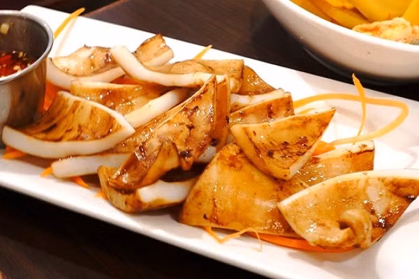 Mực nướng. Mực cũng là nguyên liệu để chế biến thành món nướng được giới trẻ rất yêu thích. Món ăn này cũng không cần phải nướng lâu, chỉ vừa chín tới là dùng được, để cho mực có độ giòn tươi và ngọt thịt. Nước sốt kèm theo món mực nướng có thể dùng để chấm với bánh mì, rất thú vị. Món mực nướng trở nên quen thuộc với teen Sài thành nên mỗi khi tụ tâp ăn uống các bạn sẽ nhớ ngay đến những món nướng đơn giản mà không kém phần hấp dẫn này.(Ảnh: lamsao.vn)