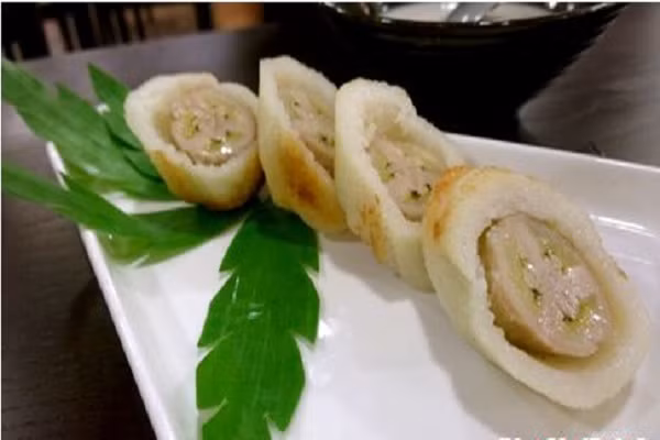 Bánh chuối cuộn nếp nướng chan cốt dừa: chuối cuốn nếp nướng với hương dừa thơm lừng quyện cùng vị thơm ngọt của chuối chín, bùi bùi của lạc. Vị ngọt thanh của trái chuối vừa chín tới thơm lừng chan cùng nước cốt dừa beo béo là món ăn vặt yêu thích của nhiều người. (Ảnh: tin247.com)