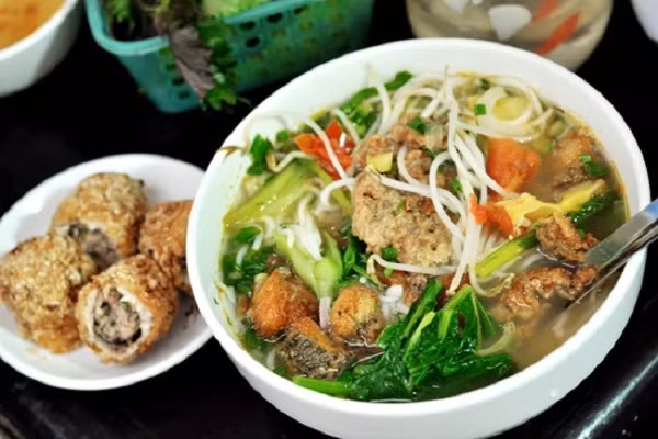 Bún cá cuốn thịt đãi cả nhà vào buổi sáng cuối tuần. Bát bún cá nóng hổi thơm lừng với những miếng chả chiên vàng ruộm, giòn tan, khi cho vào bún miếng chả vẫn giữ được hương vị của mình và không bị bở. Bên trong cá cuốn là thịt heo, mộc nhĩ được băm nhỏ và trộn đều lại với nhau, bên ngoài được bọc bởi lớp thịt cá mềm, đem cuốn lại rồi lăn qua với bột chiên xù và chiên vàng rất hấp dẫn. (Ảnh: depplus.vn)