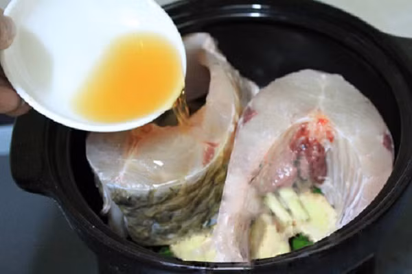 Sau đó bạn xếp cá vào nồi, cho nước mắm vào ngập khoảng 1/3 miếng cá và ướp trong khoảng 30 phút để cá ngấm gia vị và thịt đanh lại. Đặt nồi cá lên bếp, đun sôi bùng lên khoảng 5 phút rồi tắt bếp. Tiếp đó để khoảng 30 phút đến một giờ rồi bật bếp đun cá sôi lại lần hai. (Ảnh:webnauan.net)