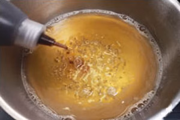 Đầu tiên, làm phần hỗn hợp bia đường nhúng bánh. Bạn hãy cho 200ml bia vào một nồi nhỏ, đặt lên bếp đun, thêm 50gr đường vào khuấy đều. Khi đường tan hết thì bạn đổ ca cao vào. Đun sôi hỗn hợp này lên cho đến khi hơi men trong bia bay đi hoàn toàn, bạn không còn ngửi thấy mùi bia nữa thì tắt bếp, để nguội. (Ảnh: Truongton).