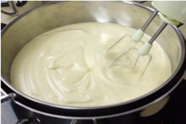 Cho hỗn hợp này vào một tô nhỏ, đặt nó trong một nồi khác to hơn có đổ sẵn nước nóng bằng 1/3 chiều cao của tô inox trên bếp, rồi tiếp tục dùng đánh trứng đánh đến khi nó bông lên. Lúc này lấy hỗn hợp kem tươi trong tủ lạnh ra, đổ vào hỗn hợp trứng, nhẹ nhàng trộn từ trên xuống dưới cho đến khi bạn có được một hỗn hợp kem trứng nhuyễn. (Ảnh: Tintuc).
