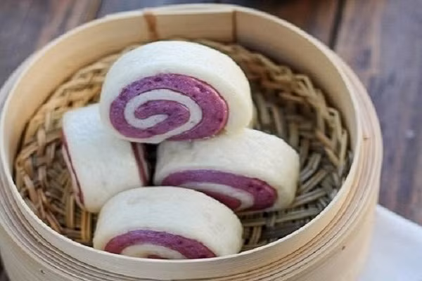 Thêm một món ăn vặt thú vị cho các bạn trẻ là món bánh bao khoai lang tím trông vô cùng bắt mắt và hấp dẫn. Chiếc bánh nóng hổi, mềm xốp, thơm thơm bùi bùi khó mà cưỡng nổi vào bữa sáng sẽ là món ăn vặt cực bổ dưỡng. Món ăn này rất dễ làm nên các bạn có thể tự trổ tài thực hiện mà không tốn nhiều thời gian và công sức. (Ảnh: eva.vn)