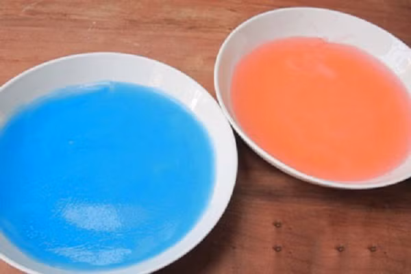 Tiếp theo, đổ thạch ra 2 bát, nhỏ vào mỗi bát một giọt màu thực phẩm khác nhau. Quấy đều để màu hòa tan vào thạch, sau đó để cho thạch nguội và đông lại.(Ảnh: phunu.net)