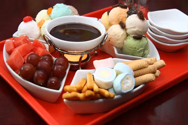 Lẩu kem. Đây thực sự là món ăn đang gây sốt và được giới trẻ cực kỳ yêu thích bởi sự đối lập giữa nóng của lẩu và lạnh của kem. Tên món lẩu có vẻ khó hiểu nhưng ngay khi bạn thưởng thức qua món ăn này, bạn sẽ bị lôi cuốn với hương vị đa dạng, ngọt mát của kem lạnh, bánh ngọt, trái cây tươi cùng sốt chocolate dùng kèm. Thích hơn, bạn có thể chọn lựa những hương vị kem yêu thích để làm thành một bàn lẩu kem của riêng mình. (Ảnh: hotdeal.vn)