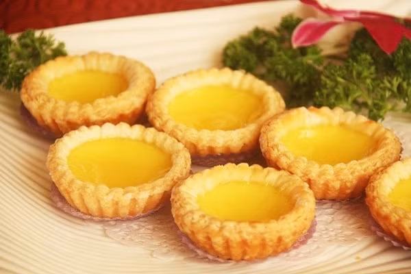 Bánh tart trứng. Biến tấu độc đáo cùng món bánh ngọt của người Bồ Đào Nha. Thực chất món bánh này được du nhập qua Hồng Kông vào thập niên 1940 và thường được bán trong các trà quán ở xứ Cảng thơm. Ngày nay, món bánh trứng nướng này trở nên phổ biến trong trào lưu đồ ăn nhanh của giới trẻ.
