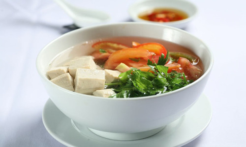 Đun nước sôi rồi cho me vào đến khi mềm thì vớt ra, cho dứa, đậu phụ, nấm rơm, cà chua và giá vào. Dầm me, chế vào nồi canh, nêm vừa chua là được. Món canh chay này ăn kèm với bún rất ngon. Ảnh: 123amthuc