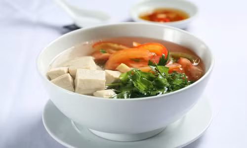 Đun nước sôi rồi cho me vào đến khi mềm thì vớt ra, cho dứa, đậu phụ, nấm rơm, cà chua và giá vào. Dầm me, chế vào nồi canh, nêm vừa chua là được. Món canh chay này ăn kèm với bún rất ngon. Ảnh: 123amthuc