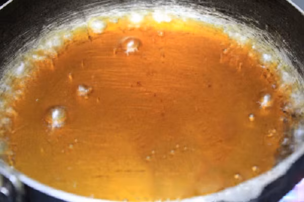 Tiếp theo bạn thắng nước màu cho cá: cho khoảng 2 muỗng cafe đường vào chảo, thêm một chút nước vừa đun vừa đảo đều cho đường tan chảy đến khi chuyển sang màu cánh gián là được. Bạn có thể dùng gói kho cá để thay thế nước màu cũng rất tiện lợi và thơm ngon. (Ảnh:webnauan.net)