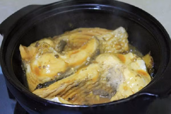 Bạn nêm lại gia vị sao cho vừa miệng rồi đậy nắp vung lại, kho cá trên lửa nhỏ liu riu đến khi cạn nước, cá chín nhừ và chuyển sang màu nâu bóng đẹp mắt. Lưu ý khi làm món cá kho riềng, nên dùng nước mắm để thịt cá chắc lại rồi cho nước màu vào, cách này giúp cá được ngấm gia vị và khi gắp vẫn giữ nguyên miếng, không bị vỡ nát. (Ảnh:webnauan.net)