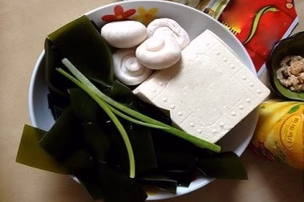 Để nấu món canh đậu phụ rong biển ngon cho ngày giao mùa bạn nên chuẩn bị những nguyên liệu sau: đậu phụ non, rong biển, nấm mỡ (có thể thay thế với loại nấm khác), tôm khô hoặc thịt bằm, gừng lát cùng các gia vị cần thiết cho món ăn. (Ảnh:Monngonmoingay)