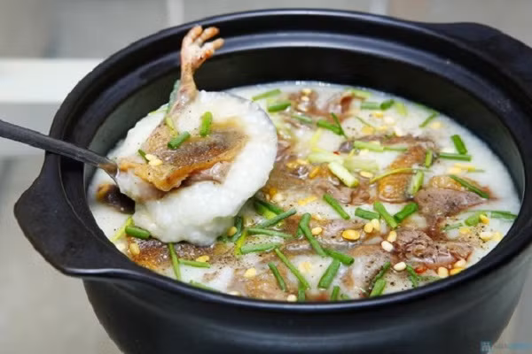 Kiểu thưởng thức lẩu cháo chim này khá lạ miệng với nước dùng chính là cháo loãng. Nước cháo bùi bùi nóng hổi, ngọt đậm đà vị thịt chim câu, hoặc cá quả, thơm thơm hương các loại nấm, rau cải cúc, chắc chắn sẽ làm bạn không thể quên được hương vị của lẩu cháo chim trong ngày mưa lạnh này.(Ảnh:khuyenmaivang.vn)