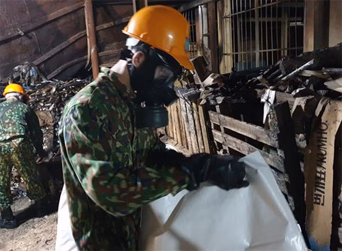 Qua đó, lực lượng tiêu độc được trang bị bảo hộ, mặt nạ chống độc đang tiến hành thu dọn. 
