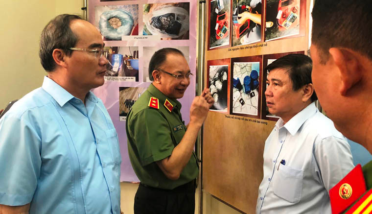 Bí thư Thành ủy TPHCM Nguyễn Thiện Nhân (người bên trái), Chủ tịch UBND TPHCM Nguyễn Thành Phong được Trung tướng Lê Đông Phong, giám đốc Công an TPHCM báo cáo quá trình 12 ngày đêm phá nhanh vụ án "khủng bố nhằm lật đổ chính quyền nhân dân".