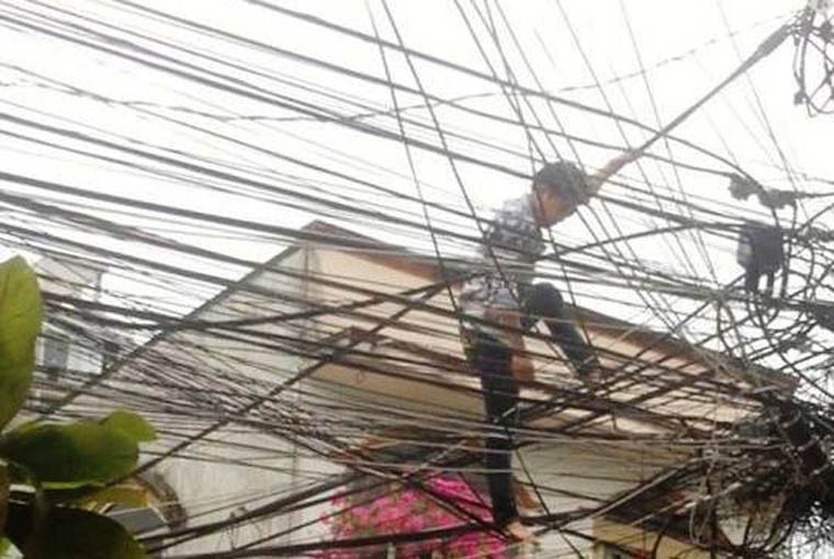 Nam thanh niên đi trên dây điện và liên tục nói lảm nhảm “xuống đất sợ bị giang hồ chém”.