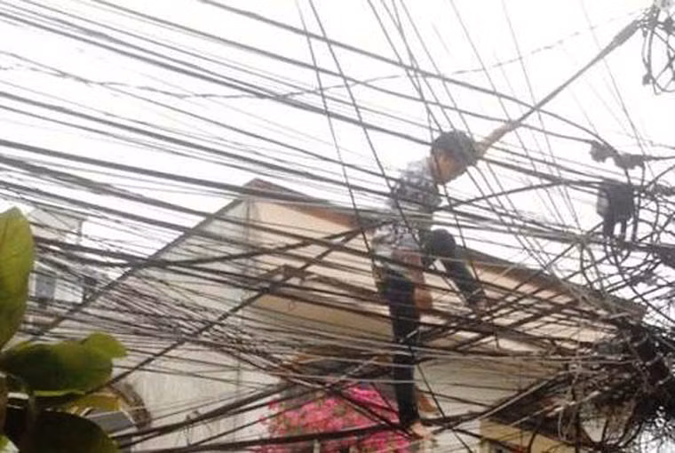 Nam thanh niên đi trên dây điện và liên tục nói lảm nhảm “xuống đất sợ bị giang hồ chém”.