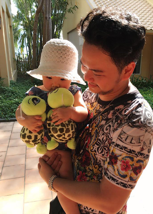 Ông xã Trang Nhung bồng bé Vani. Cô nhóc tỏ ra rất thích thú với hai chú rùa bằng bông.