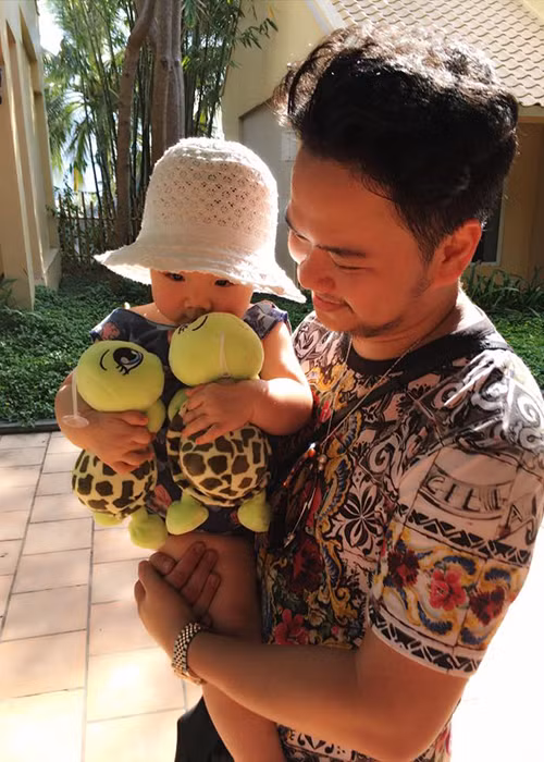 Ông xã Trang Nhung bồng bé Vani. Cô nhóc tỏ ra rất thích thú với hai chú rùa bằng bông.