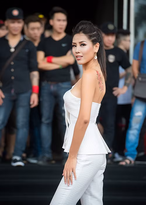 Á hậu Nguyễn Thị Loan khoe hình xăm những bông hoa trên vai trái khi xuất hiện trên thảm đỏ của lễ hội xăm hình nghệ thuật Quốc tế. 