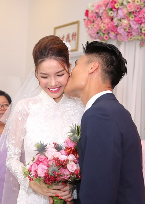 Nữ người mẫu 9x xinh đẹp trong bộ áo dài ren trắng. Cô tỏ ra khá bối rối khi nhận nụ hôn từ Mạc Hồng Quân. (Ảnh: Tiền phong)