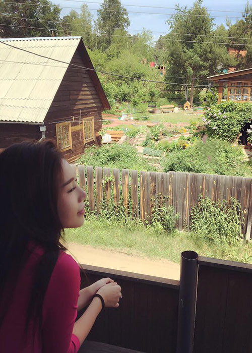 Người đẹp tận hưởng khoảng thời gian thư thái khi ngắm nhìn cảnh yên bình từ một ngôi nhà nhỏ ở xứ Bạch dương.