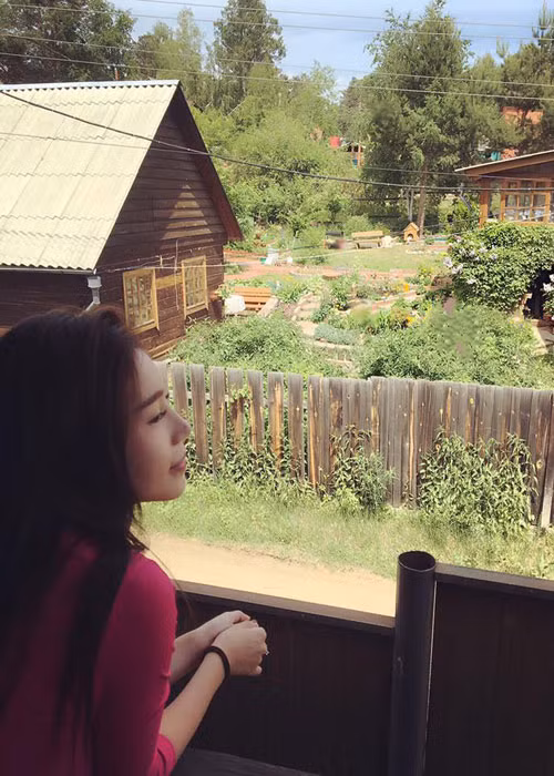 Người đẹp tận hưởng khoảng thời gian thư thái khi ngắm nhìn cảnh yên bình từ một ngôi nhà nhỏ ở xứ Bạch dương.