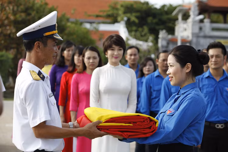 Nguyễn Thị Huyền duyên dáng trong tà áo dài trắng tại lễ trao lá cờ từ cột cờ Lũng Cú đến với Trường Sa.