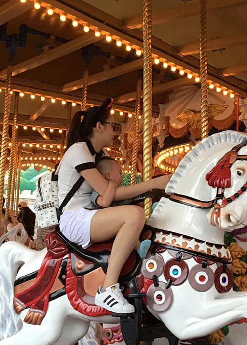 Cùng mẹ tham gia trò cưỡi ngựa gỗ ở một khu vui chơi giải trí ở Tokyo, bé Ricky khá sợ hãi.