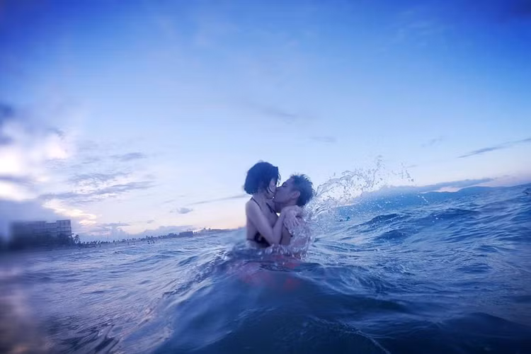 Cặp đôi không ngần ngại trao cho nhau nụ hôn nóng bỏng trong chuyến du lịch biển sau khi hot girl 8x sinh con đầu lòng được hơn 2 tháng. (Ảnh: Facebook Tâm Tít)