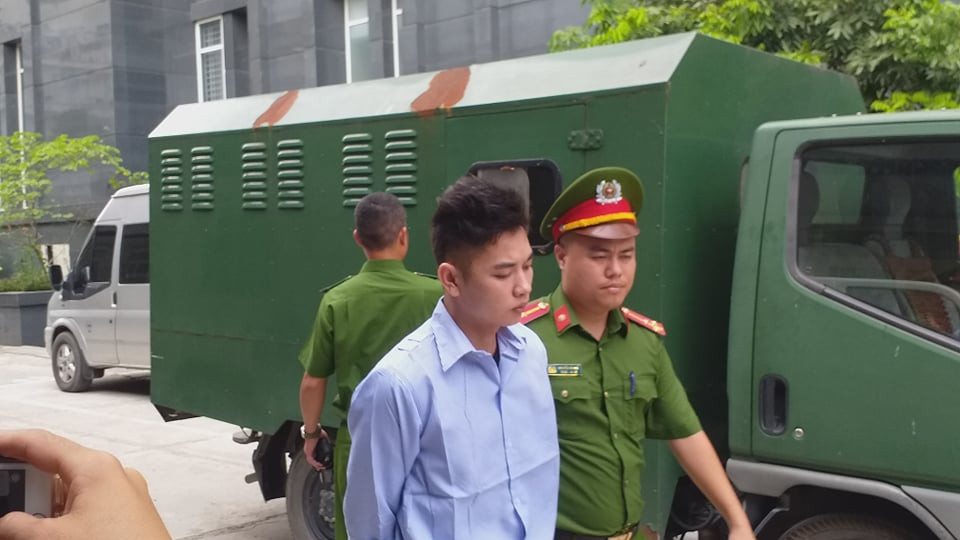 Cơ quan công an giải hai bị cáo đến phòng xét xử.