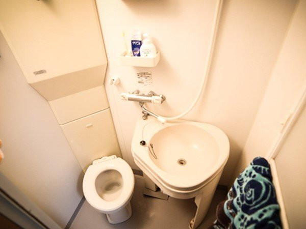 Phòng tắm được thiết kế với một bồn rửa có thể xoay giúp che bồn cầu.