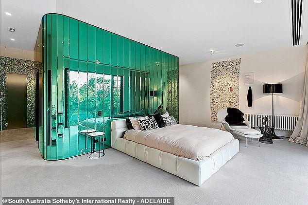 Phòng ngủ nổi bật với mảng tường đính gương xanh vừa tạo điểm nhấn vừa phản chiếu hình ảnh ngoài trời khiến căn phòng hài hòa với thiên nhiên nhưng cũng không kém phần ấn tượng.