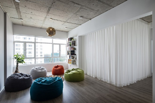 Phòng khách được thiết kế đơn giản, điểm nhấn là những chiếc ghế nhiều màu sắc. Ngoài ra, một trong 3 phòng ngủ không được thiết kế "cứng" mà kết hợp linh hoạt cùng với phòng khách.