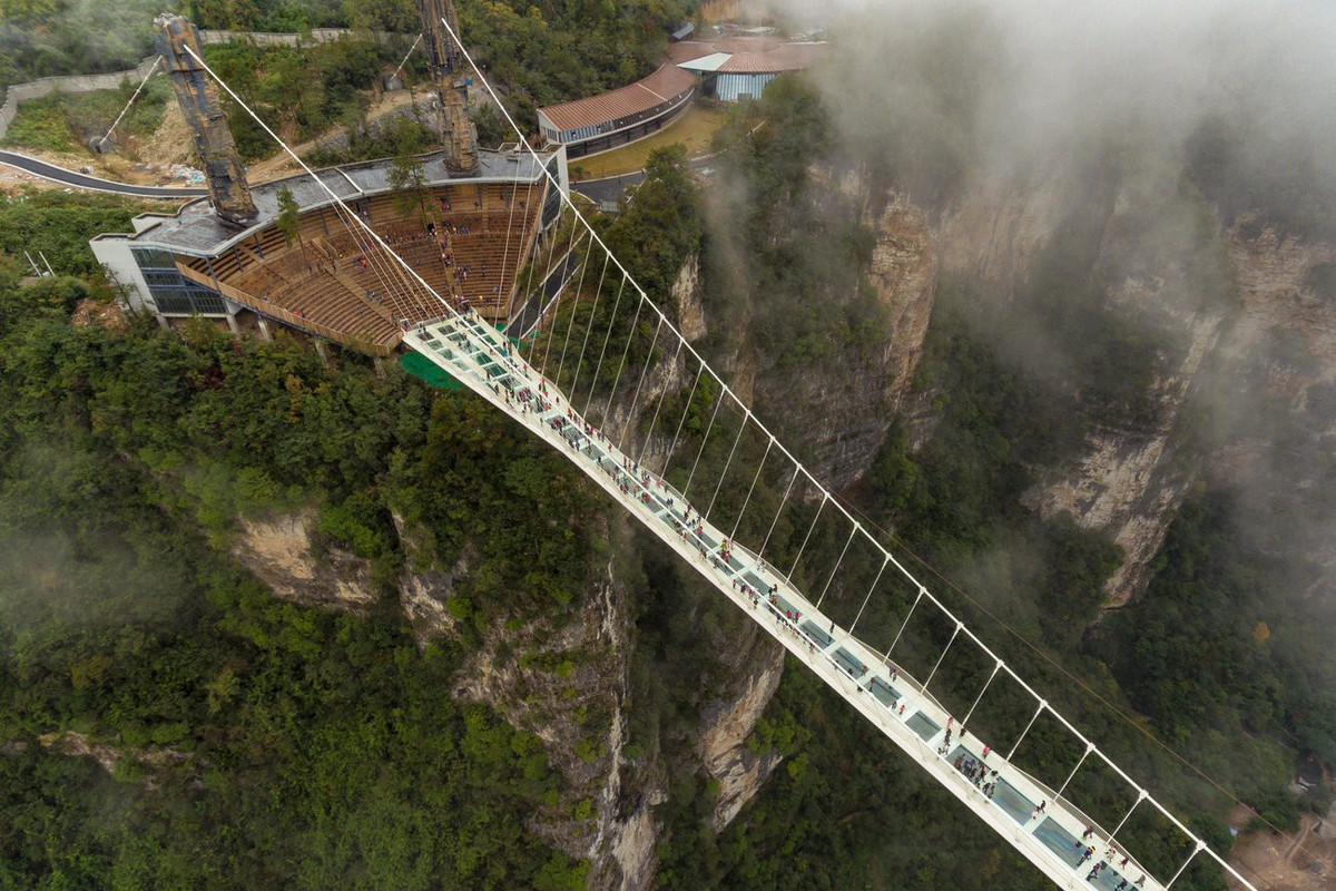 Cầu kính Trương Gia Giới (Trung Quốc): Lối đi đáng sợ 430 m, ở độ cao 300 m so với thung lũng phía dưới là điểm đến hút khách bậc nhất Trung Quốc. Trước khi đưa vào hoạt động, người ta đã dùng búa đập để thử sức chịu lực của cây cầu nhằm chứng minh độ an toàn của nó. Tuy nhiên, cây cầu kính cao nhất thế giới cũng không thoát khỏi số phận bị đóng cửa từ tháng 10. Ảnh: Getty images.