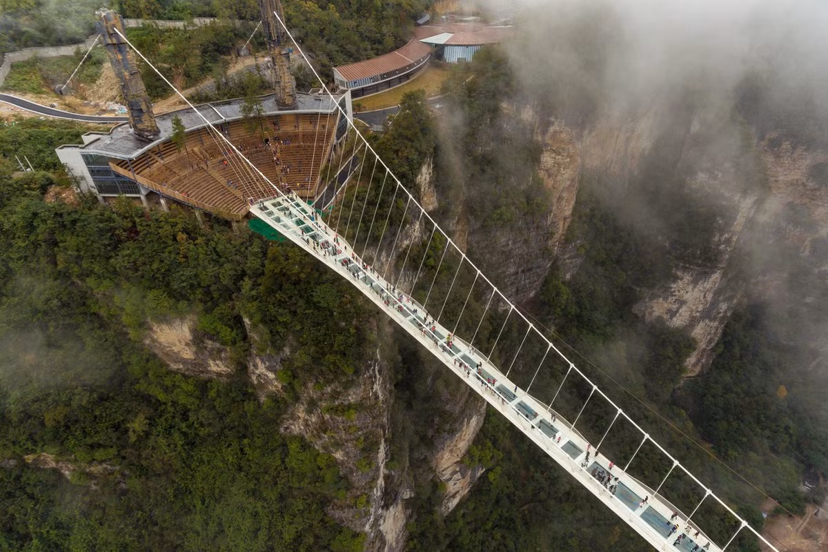 Cầu kính Trương Gia Giới (Trung Quốc): Lối đi đáng sợ 430 m, ở độ cao 300 m so với thung lũng phía dưới là điểm đến hút khách bậc nhất Trung Quốc. Trước khi đưa vào hoạt động, người ta đã dùng búa đập để thử sức chịu lực của cây cầu nhằm chứng minh độ an toàn của nó. Tuy nhiên, cây cầu kính cao nhất thế giới cũng không thoát khỏi số phận bị đóng cửa từ tháng 10. Ảnh: Getty images.