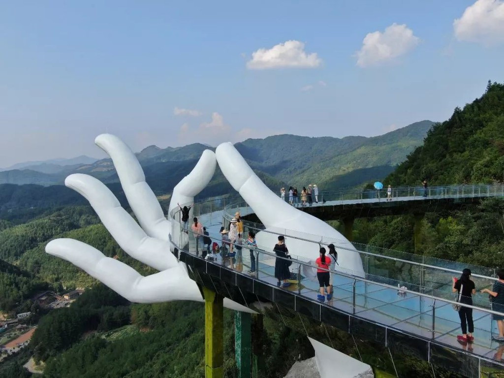 Cầu kính Thái Hồng Tiên Thủ (Trung Quốc): Công trình ở tỉnh Phúc Kiến, Trung Quốc, từng gây tranh cãi vì có tạo hình giống với Cầu Vàng nổi tiếng ở Việt Nam. Cây cầu có mặt kính trong suốt dài 99 m, uốn cong, tạo cho du khách cảm giác hồi hộp khi bước đi. Đứng trên cầu, du khách có thể phóng tầm mắt ngắm nhìn khung cảnh hùng vĩ xung quanh. Thậm chí nhiều thời điểm trong ngày, mặt kính hiện lên hiệu ứng cầu vồng và kính nứt dọa khách. Ảnh: Lotour, kuaibao.