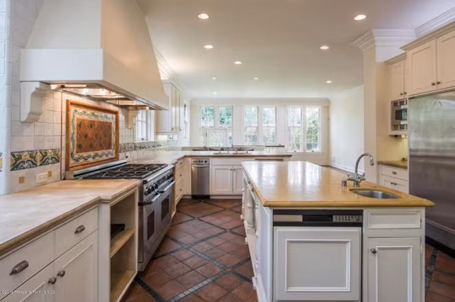 Nhà bếp lộng lẫy với bức tường đá có họa tiệt sặc sỡ. Các trang thiết bị hiện đại, cao cấp được tích hợp bên trong những chiếc tủ cỡ lớn. Các ô cửa sổ cung cấp ánh sáng tự nhiên và giúp không gian trở nên thoáng đãng hơn.